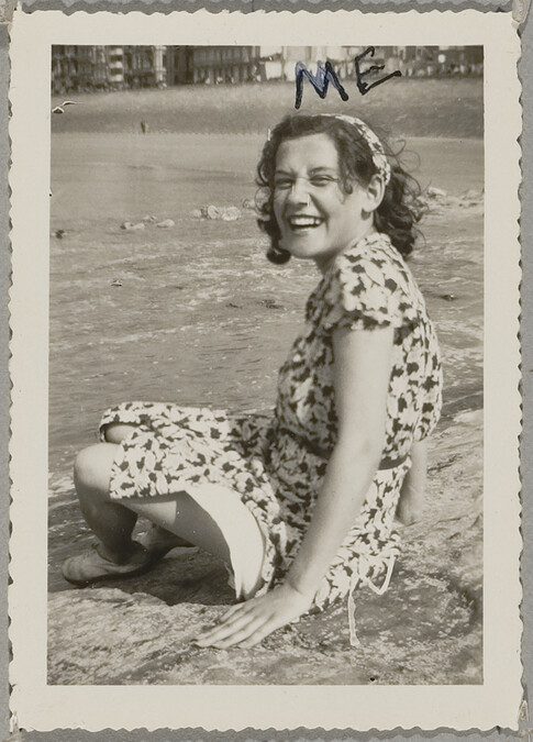 Young Woman Sitting in Print Dress on Grass