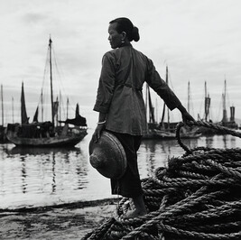 Woman overlooking harbor, China