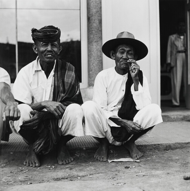 Two squatting men, Indonesia