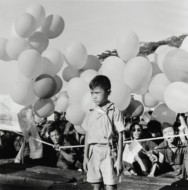 Boy with balloons at political rally, Indonesia