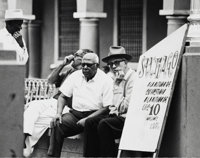 Men on street bench, Cuba