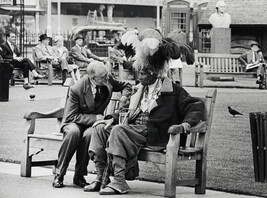 Two men conversing on a park bench, London, UK