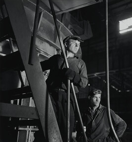 Two factory workers posed on a staircase