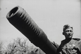 Soldier posing beside his artillery