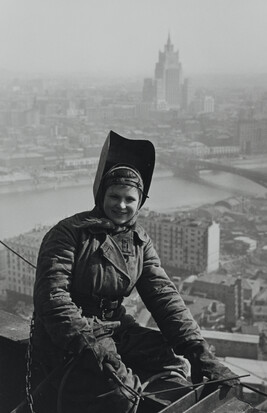 Steeplejack A. Pushkova perched atop a girder of the Hotel Ukraine with a Stalin Building in the...