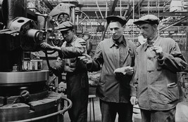 Technical Engineer H. V. Norets (center) explains his innovation to colleague A. M. Ivanov, as machinist...