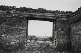 Soldiers with wagon seen from blown-out brick building