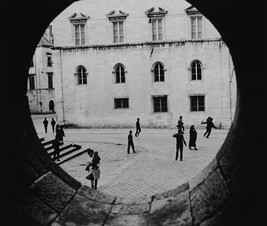 Youths Playing in Town Square Seen Throught Circular Window, Yugoslavia