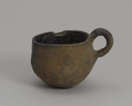 Cup with a loop handle and rounded base.