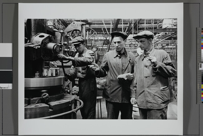Alternate image #1 of Technical Engineer H. V. Norets (center) explains his innovation to colleague A. M. Ivanov, as machinist V. P. Alekseev looks on, Kirov Tractor Factory, Ural Industrial Complex