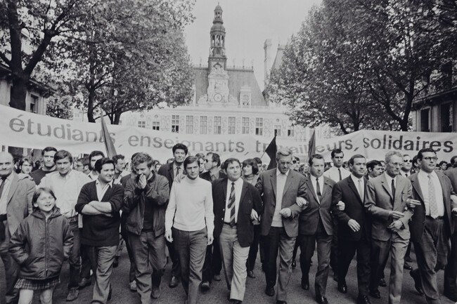 Student leaders Alain Geismar (arms crossed), Daniel Cohn-Bendit (hands in front of his face), and Jacques Sauvageot (in turtleneck) march together during student/worker demonstration, March 13, 1968