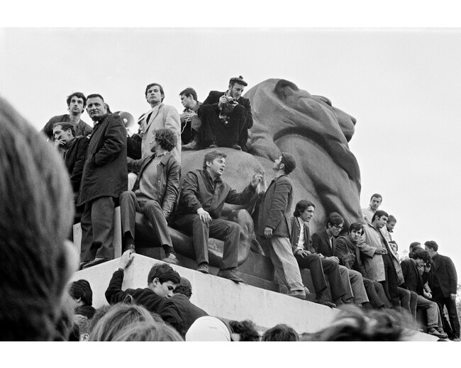 Demonstrators (including Daniel Cohn-Bendit sitting with left hand raised) on Le Lion de Bellfort (1880) by sculptor Francois Auguste Bartholdi at Place Denfert-Rochereau, May 10, 1968