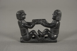 Argillite Carving of Two Facing Seating Anglo-European Men Pulling a Cylinder