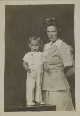 Young Woman in a Summer Suit Standing beside a Toddler Boy (standing on a table)