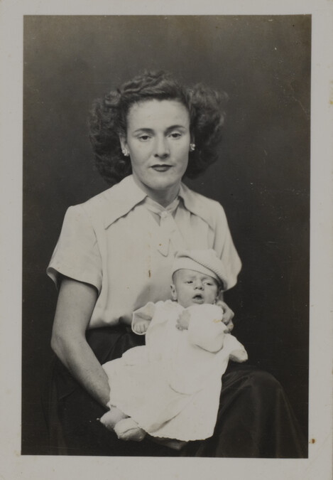 Woman in Blouse with Accented Shoulders Holding a Baby on her Lap