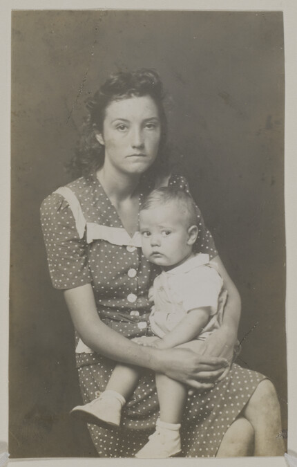 Woman in Polka Dot Dress, Holding a Toddler on her Lap