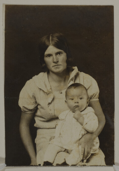 Woman in Dress with a Baby Seated on her Lap