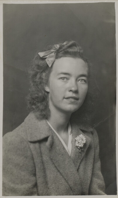Woman in Coat with a Bow in her Hair a Lapel Pin