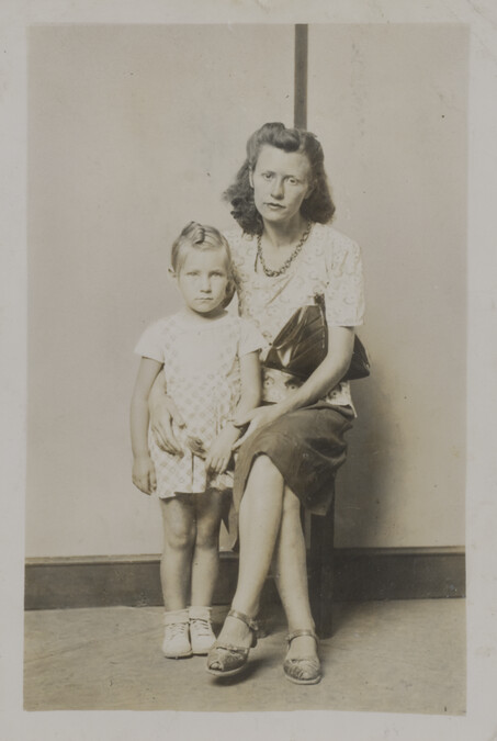 A Seated Woman with her Arm Around a Little Girl (in front of a striped background)