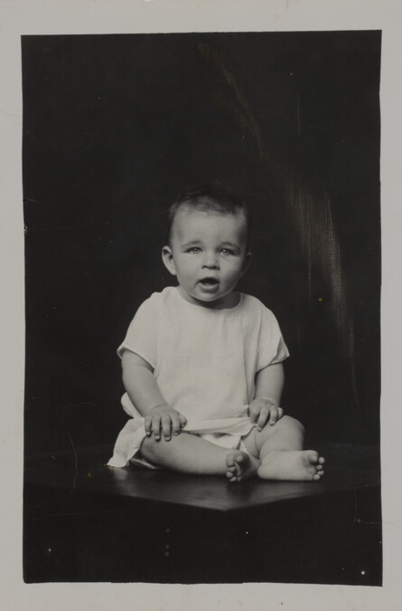 Toddler in  a Loose Shirt (seated on a table)