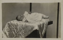 Baby Lying on a Satin Blanket on a Table (striped background)