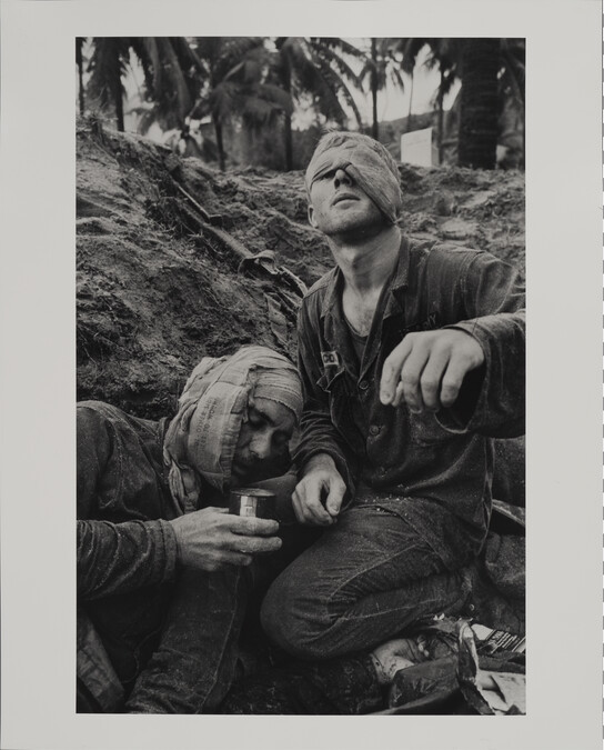 Medic Thomas Cole of Richmond, Virginia, Looks up with his One Unbandaged Eye as he Continues to Treat Wounded S.Sgt. Harrison Pell of Hazleton, Pennsylvania, During a Firefight, January 30, 1966
