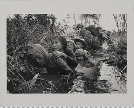Women and Children Crouch in a Muddy Canal as they Take Cover from Intense Viet Cong Fire, January 1,...