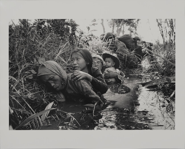 Women and Children Crouch in a Muddy Canal as they Take Cover from Intense Viet Cong Fire, January 1, 1966