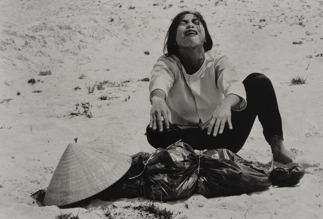 A Woman Mourns Over the Body of her Husband After Identifying him by his Teeth, and Covering his Head with her Conical Hat.  The Man’s Body was Found with Forty-Seven Others in a Mass Grave Near Hue, April 11, 1969