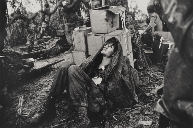 A U. S. Paratroooper Wounded in the Battle for Hamburger Hill Grimaces in Pain as he Awaits Medical Evacuation at Base Camp Near the Laotian Border, May 19, 1969