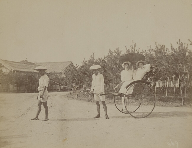 Man standing next to a woman in a rickshaw pulled by two Japanese men. Kamakura, Kanagawa Prefecture, Japan, from a Travel Photograph Album (Views of Hawaii and Japan)