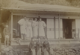 Four Western tourists with three Japanese women and a boy outside a tea house. Enoshima, Kanagawa...