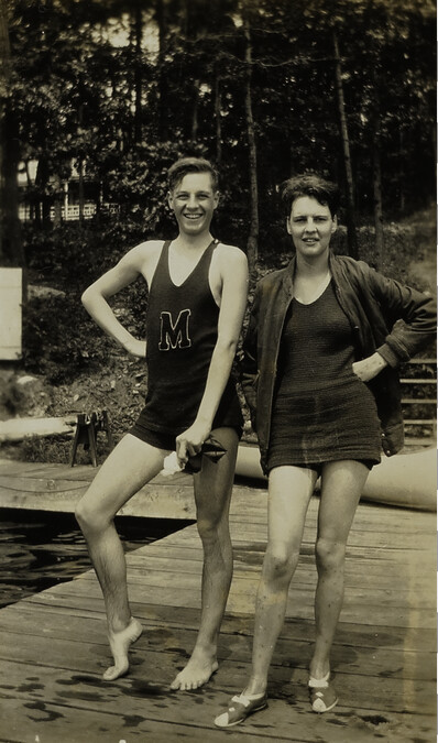 Young Man and Woman Standing on Dock at Lake [Youth has an M on his tank top]