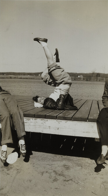 Woman with Feet in Air on Dock near River or Lake