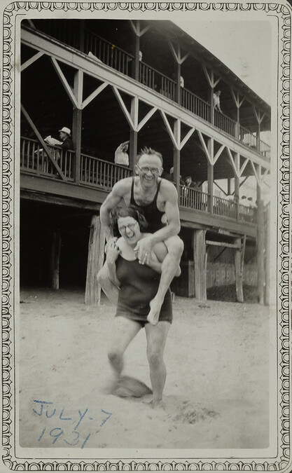 Woman Carrying a Man Piggy Back at Beach