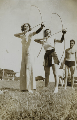 Two Young Women Doing Archery, Man Watching