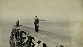 Two Men on Dock with Steam Ship in Distance