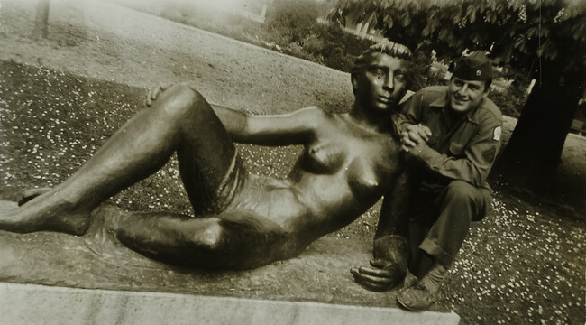 Man Seated next to Nude Statue of a Woman