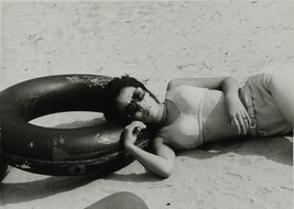Woman Wearing Sunglasses Leaning on Inner Tube at Beach