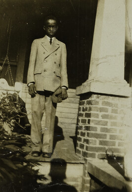 “Doing My Best” [Young Man in Suit Standing on Porch] [from the Photo Album of an African-American Woman]...